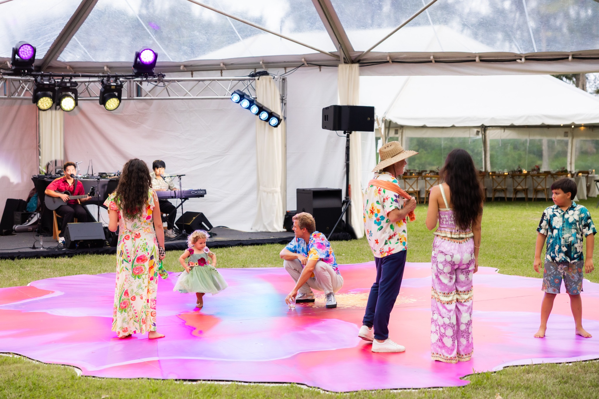 Adults and children enjoying the hibiscus dance floor in front of a live band